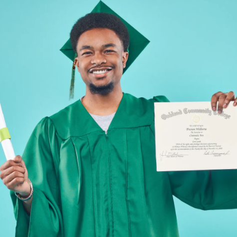Student posing in cap and gown holding diploma